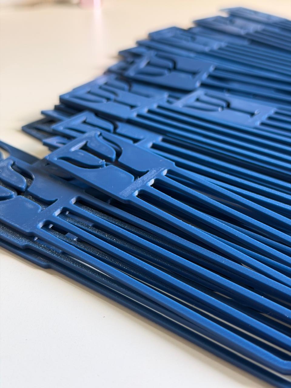 Marca-páginas personalizados azuis empilhados, produzidos em impressão 3D