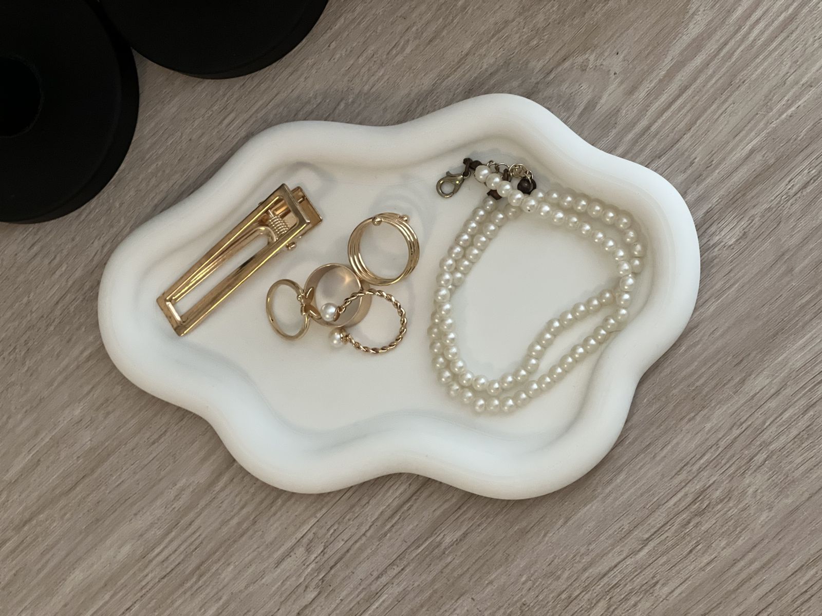 Bandeja orgânica branca porta-joias com anéis, presilha e colar de pérolas